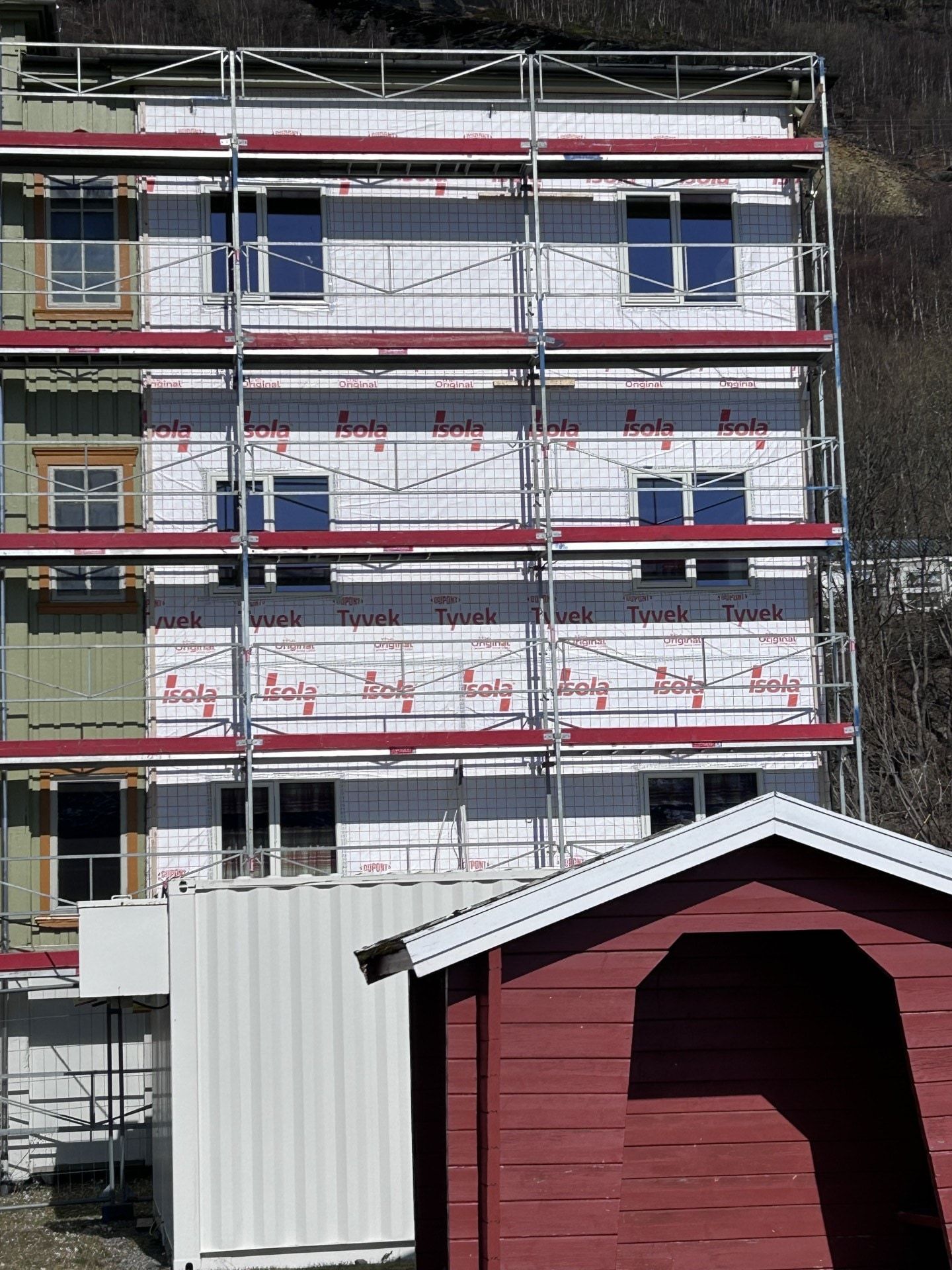Flerboligbygg med full stillas under etterisolering