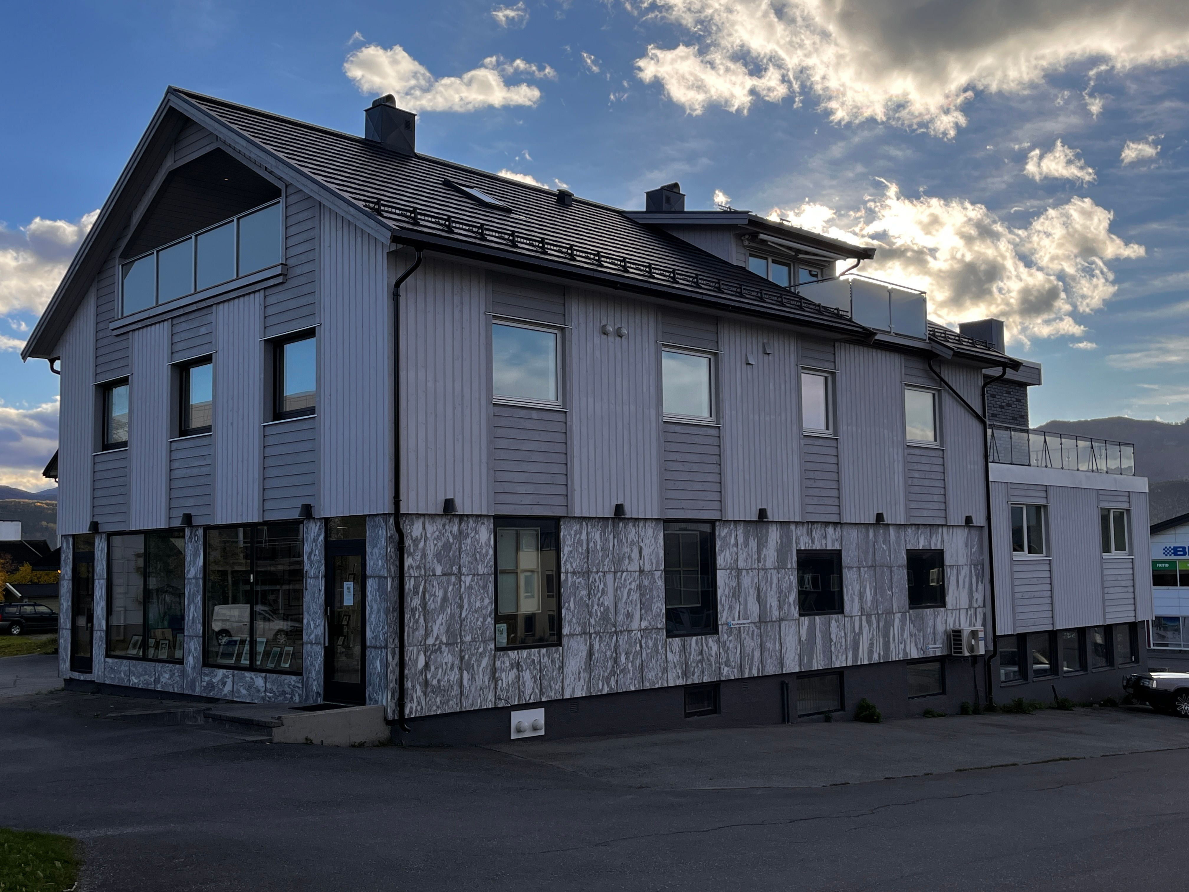 Rehabilitert næringsbygg med dramatisk himmel